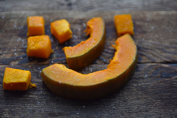baked orange pumpkin sliced on a wooden table