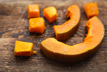baked orange pumpkin sliced on a wooden table