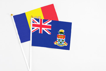 Fototapeta premium Cayman Islands and Andorra stick flags on white background. High quality fabric, miniature national flag. Peaceful global concept.White floor for copy space.