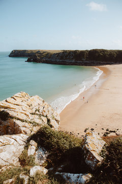 Idyllic view of green water deserted seashore and bare rocks in Barafundle Bay on sunny day