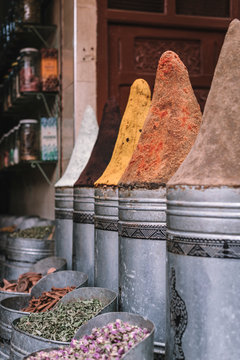 Assorted aromatic spices in metal containers placed on stall on marketplace on street of Marrakesh, Morocco