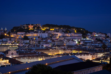 Fototapeta na wymiar Scenic view of the Sao Jorge Castle (Saint George Castle, Castelo de Sao Jorge) and Alfama district in downtown Lisbon, Portugal at dusk. Viewed from the Miradouro de Sao Pedro de Alcantara viewpoint.
