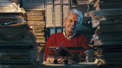 Senior office worker with vintage toy plane