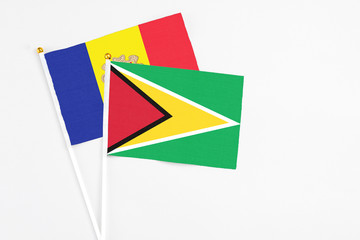 Fototapeta premium Guyana and Andorra stick flags on white background. High quality fabric, miniature national flag. Peaceful global concept.White floor for copy space.