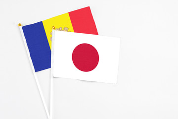 Japan and Andorra stick flags on white background. High quality fabric, miniature national flag. Peaceful global concept.White floor for copy space.