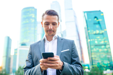 Fototapeta premium Young caucasian man holding smartphone for business work.