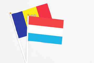 Luxembourg and Andorra stick flags on white background. High quality fabric, miniature national flag. Peaceful global concept.White floor for copy space.