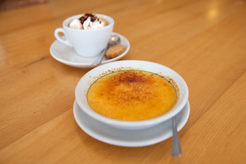coffee with cream and creme brulee on the table in  cafe