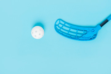 floorball stick and white ball isolated on blue background