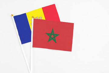 Morocco and Andorra stick flags on white background. High quality fabric, miniature national flag. Peaceful global concept.White floor for copy space.