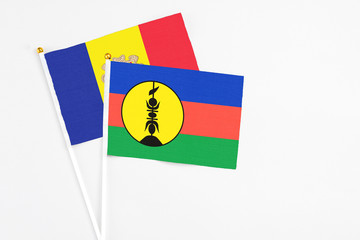 New Caledonia and Andorra stick flags on white background. High quality fabric, miniature national flag. Peaceful global concept.White floor for copy space.