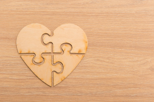 Heart Shape Jigsaw Puzzle On Wooden Background
