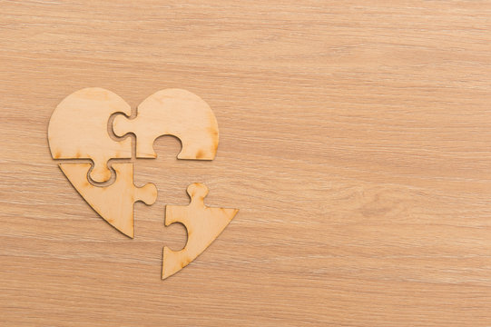 Heart Shape Jigsaw Puzzle On Wooden Background