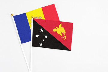 Papua New Guinea and Andorra stick flags on white background. High quality fabric, miniature national flag. Peaceful global concept.White floor for copy space.