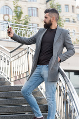 Glad to see you. Man taking selfie photo smartphone urban background. Streaming online video call....