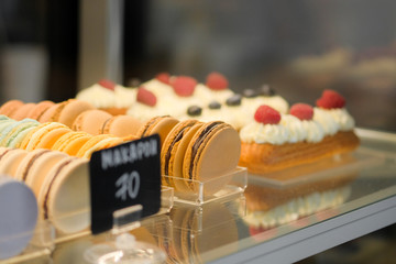 Pastry shop display window of delicatessen store with variety of cakes.