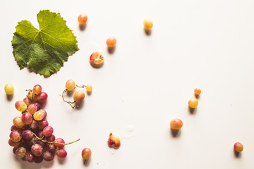 Ripe red grape with leaves isolated on white