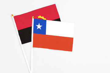 Chile and Angola stick flags on white background. High quality fabric, miniature national flag. Peaceful global concept.White floor for copy space.