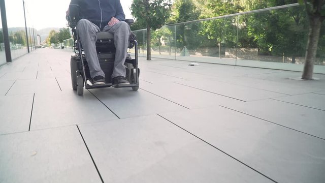 4k resolution closeup follow from front of a man on electric wheelchair driving on a street. Accessibility concept