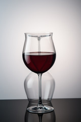 red wine in a wine glass behind it is still a glass on the background1