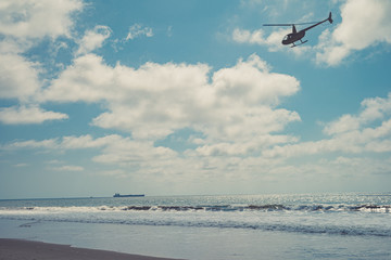 Helicopter patrols over the ocean beach