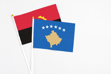 Kosovo and Angola stick flags on white background. High quality fabric, miniature national flag. Peaceful global concept.White floor for copy space.