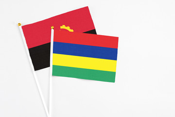 Mauritius and Angola stick flags on white background. High quality fabric, miniature national flag. Peaceful global concept.White floor for copy space.