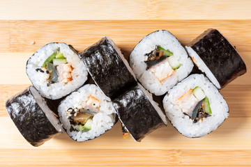 Maki with crab, avocado and mussel. On the plank.