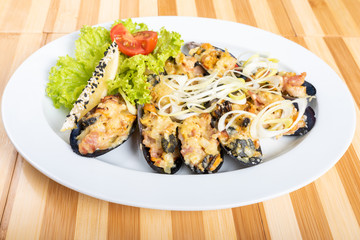 Baked mussels in half shell with filling and side dish.