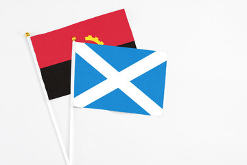 Scotland and Angola stick flags on white background. High quality fabric, miniature national flag....