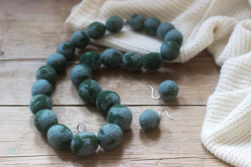 Wool jewelry against the background of a pullover or sweater, felting.