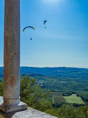 Fototapeta na wymiar Actividad de aventura, parapente en el cielo azul de Motovun, en la península de Istria, Croacia, verano de 2019