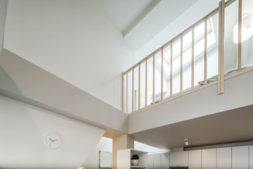 Second floor in private house. Modern light interior. Wooden railing.