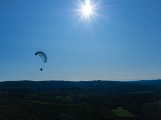 Fototapeta na wymiar Actividad de aventura, parapente en el cielo azul de Motovun, en la península de Istria, Croacia, verano de 2019