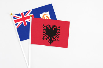 Albania and Anguilla stick flags on white background. High quality fabric, miniature national flag. Peaceful global concept.White floor for copy space.