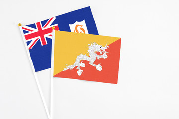Bhutan and Anguilla stick flags on white background. High quality fabric, miniature national flag. Peaceful global concept.White floor for copy space.