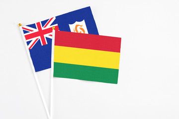 Bolivia and Anguilla stick flags on white background. High quality fabric, miniature national flag. Peaceful global concept.White floor for copy space.