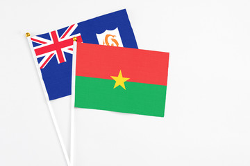 Burkina Faso and Anguilla stick flags on white background. High quality fabric, miniature national flag. Peaceful global concept.White floor for copy space.