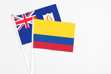 Colombia and Anguilla stick flags on white background. High quality fabric, miniature national flag. Peaceful global concept.White floor for copy space.