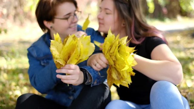 Charming young women kissing gently loving each other stroking touching face skin enjoying romantic tender moments on picnic date in the countryside.