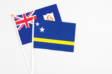 Curacao and Anguilla stick flags on white background. High quality fabric, miniature national flag. Peaceful global concept.White floor for copy space.