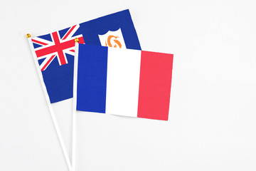 France and Anguilla stick flags on white background. High quality fabric, miniature national flag. Peaceful global concept.White floor for copy space.