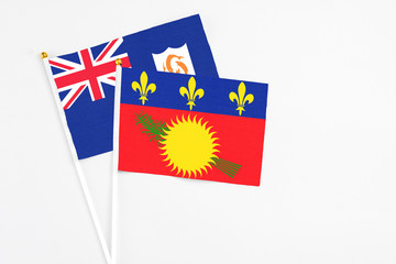 Guadeloupe and Anguilla stick flags on white background. High quality fabric, miniature national flag. Peaceful global concept.White floor for copy space.