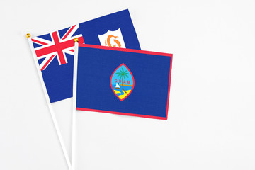 Fototapeta premium Guam and Anguilla stick flags on white background. High quality fabric, miniature national flag. Peaceful global concept.White floor for copy space.