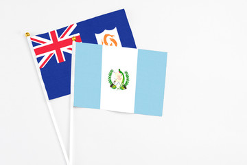 Guatemala and Anguilla stick flags on white background. High quality fabric, miniature national flag. Peaceful global concept.White floor for copy space.
