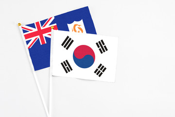 South Korea and Anguilla stick flags on white background. High quality fabric, miniature national flag. Peaceful global concept.White floor for copy space.
