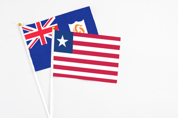 Liberia and Anguilla stick flags on white background. High quality fabric, miniature national flag. Peaceful global concept.White floor for copy space.