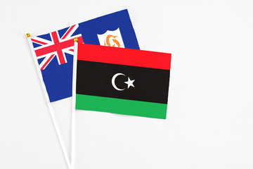 Libya and Anguilla stick flags on white background. High quality fabric, miniature national flag. Peaceful global concept.White floor for copy space.