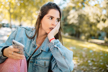 Closeup portrait of stressed woman holding cellphone worried wit