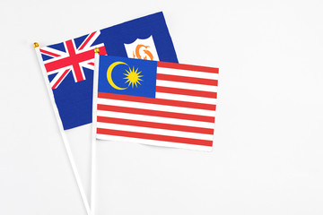 Malaysia and Anguilla stick flags on white background. High quality fabric, miniature national flag. Peaceful global concept.White floor for copy space.